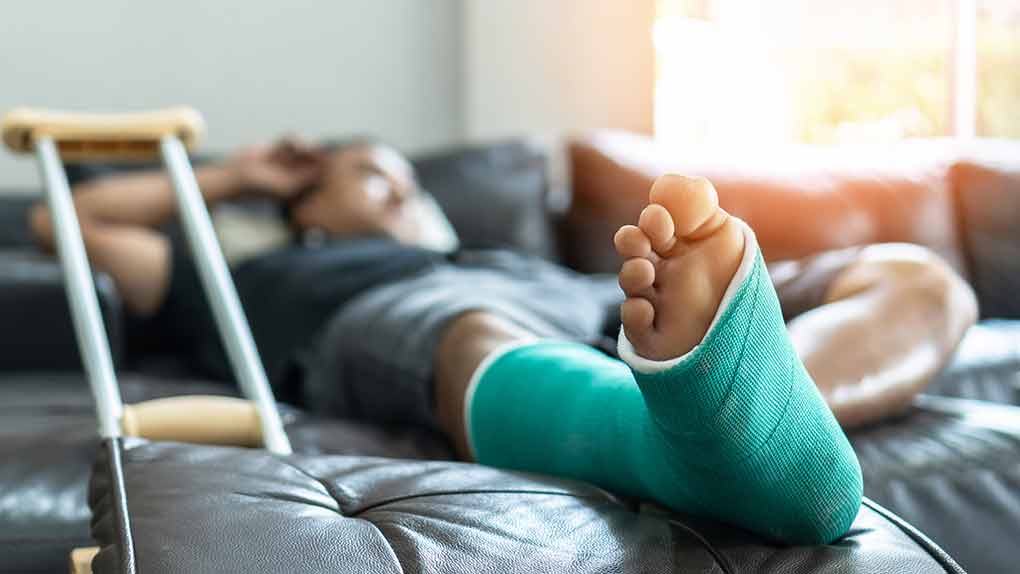 Many lying on couch with foot in cast.