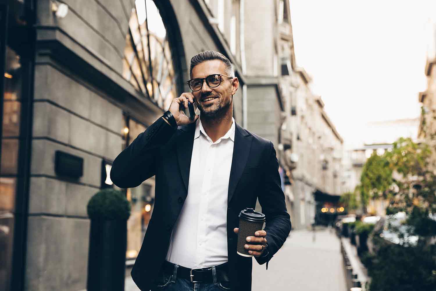 Man able to walk and talk on the phone while carrying a coffee