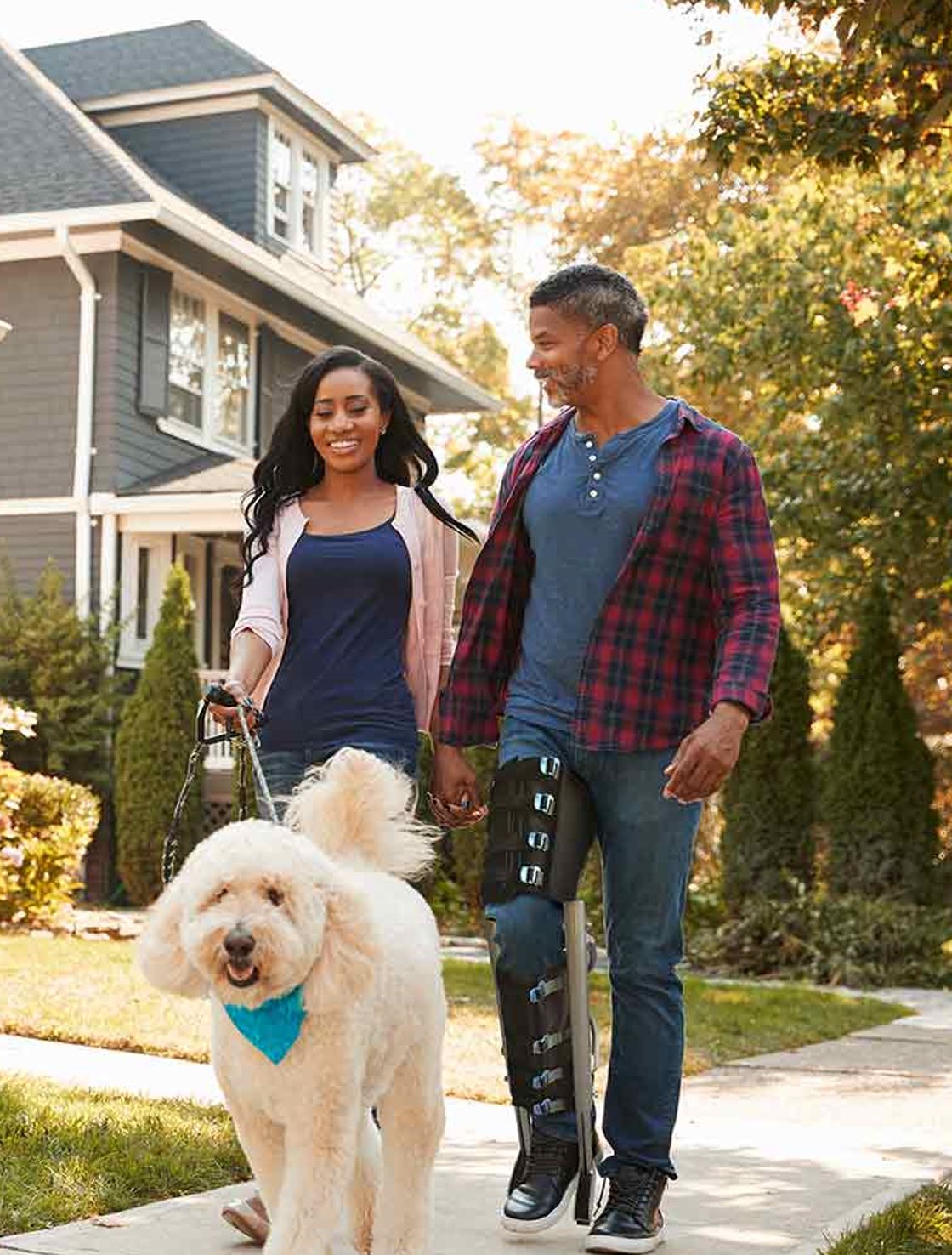 Couple walking a dog, man is wearing an XLEG